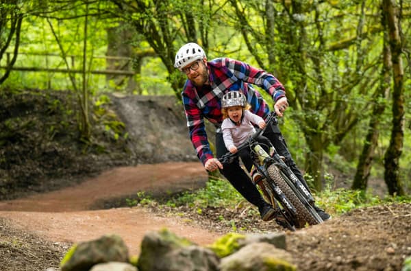 Family cycling around berms in the Forest of Dean photo credit Forestry England