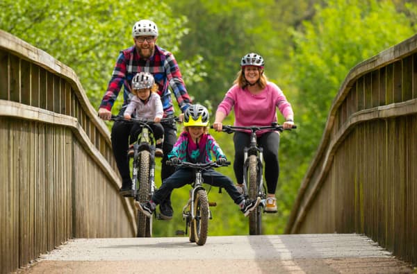 Family cycling over a bridge in the Forest of Dean photo credit Forestry England