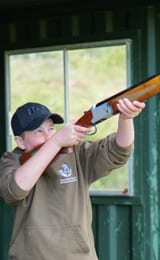 A kid taking a shot at a clay pigeon with a laser shotgun at Dean Laser Clay Ltd