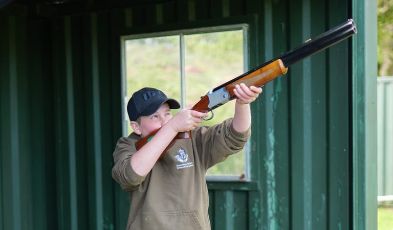 A kid taking a shot at a clay pigeon with a laser shotgun at Dean Laser Clay Ltd