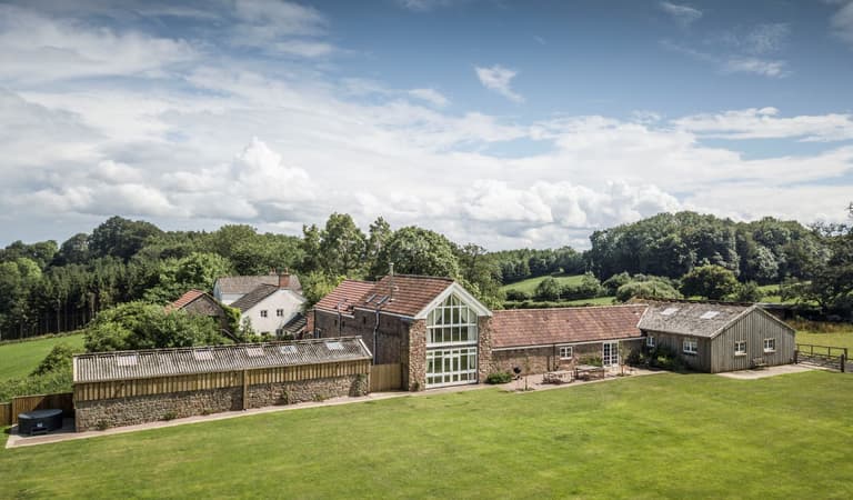 Stay at Lydney Park Estate and Gardens. Lodge Barn - aerial view of the generous outdoor space, quiet rural location and spacious accommodation at Lodge Barn.