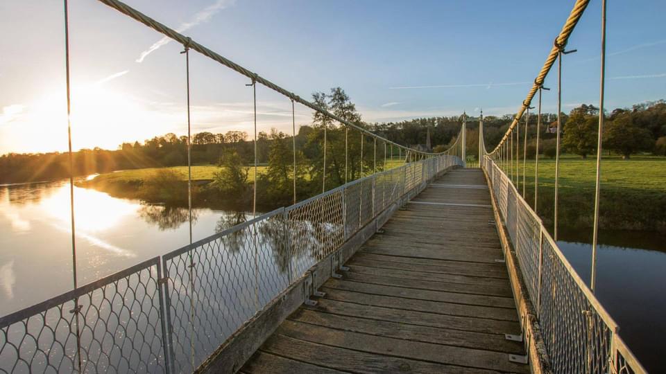 Walking over a bridge with the sun setting in the Forest of Dean and Wye Valley