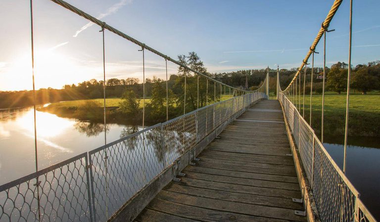 Walking over a bridge with the sun setting in the Forest of Dean and Wye Valley
