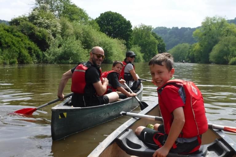 Family on a canoe on the River Wye enjoying a summer day.